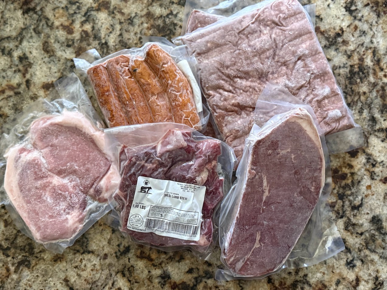 The Trio meat bundle with pasture-raised beef, pork chops, smoked sausage, and lamb stew from Clover Leaf Farm