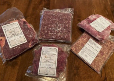 Beef and pork combo box featuring vacuum-sealed ground beef, pork sausage, stew beef, roast, and pork chops from Clover Leaf Farm Meats